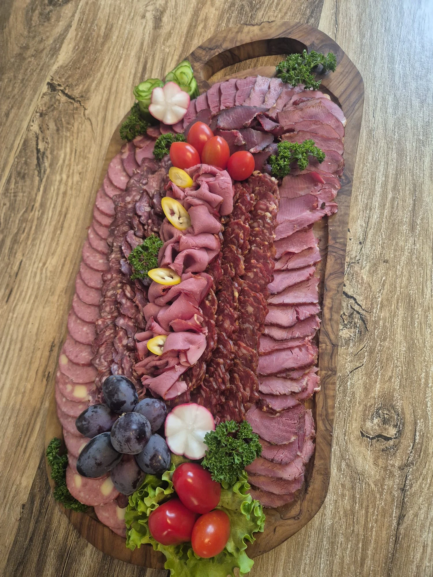 Florians Fleisch- und Wurstspezialitäten auf einem dekorierten Holzbrett