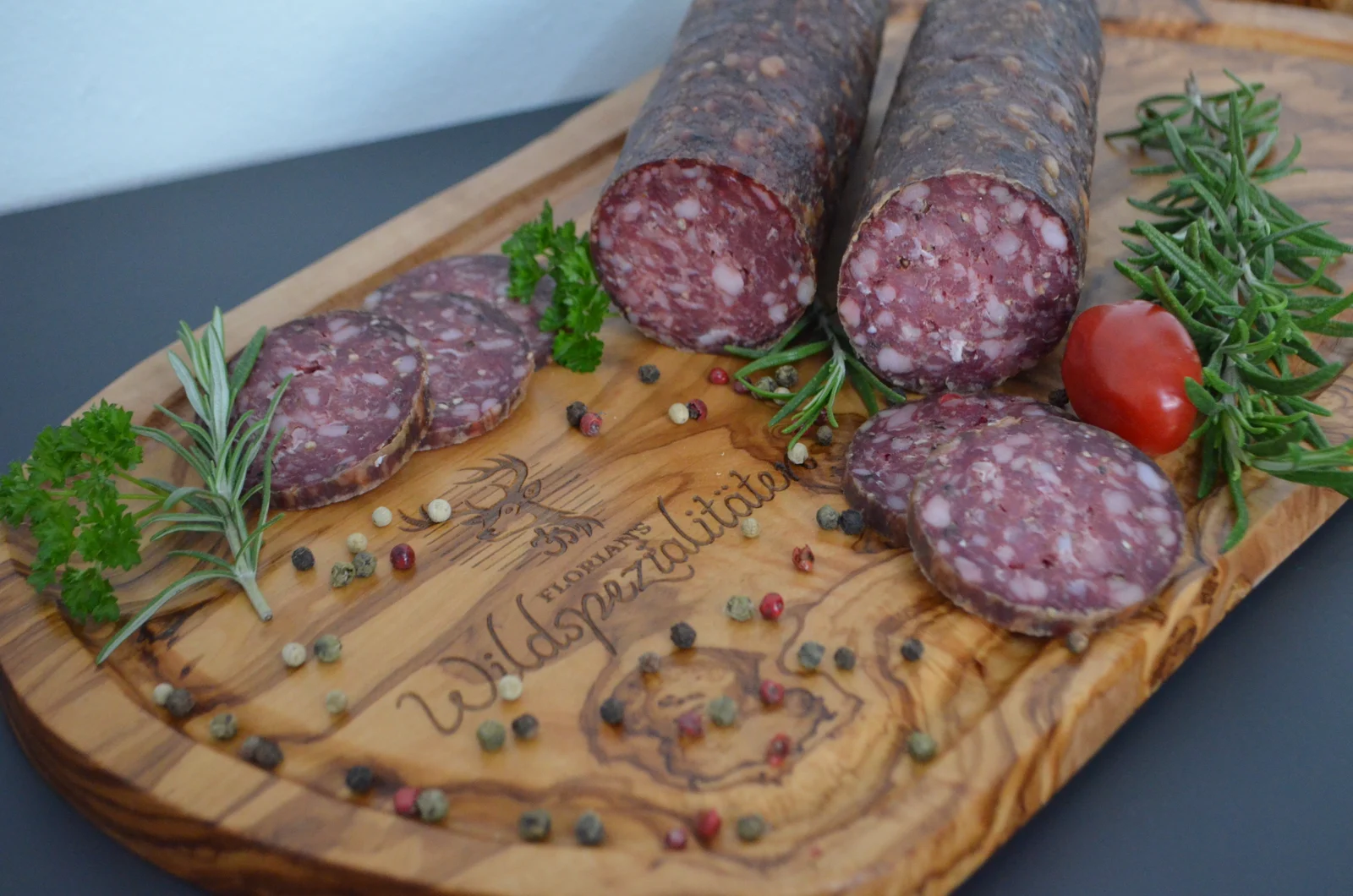 Florians Salamispezialitäten mit Kräutern auf einem Holzbrett
